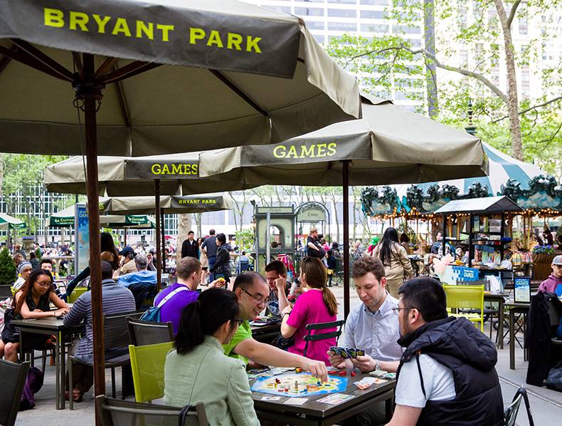 People enjoying outdoor table games next to vending kiosks
